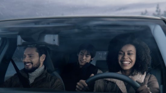 Three passengers riding in a vehicle and smiling | Coastal Nissan in Norwell MA