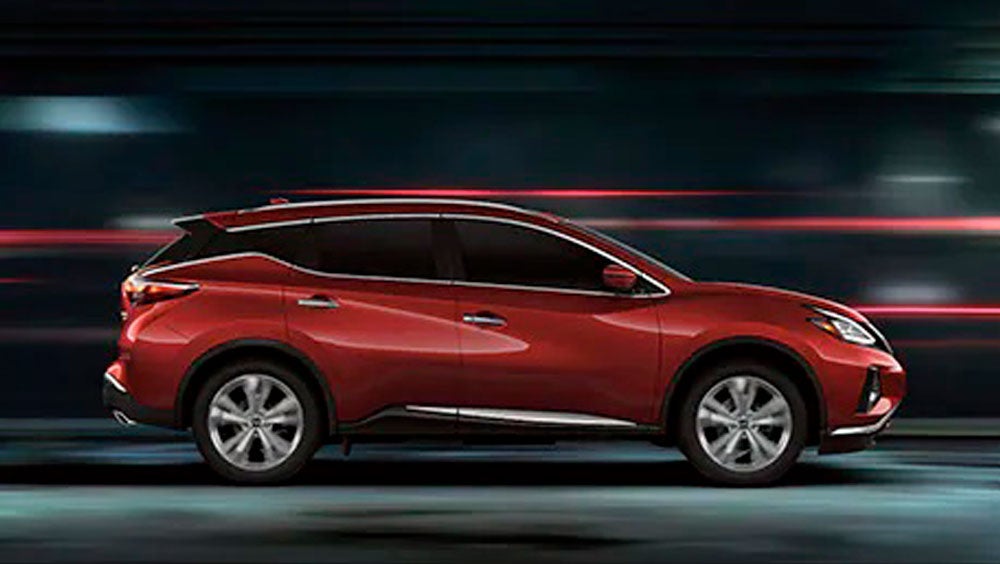 2023 Nissan Murano shown in profile driving down a street at night illustrating performance. | Coastal Nissan in Norwell MA